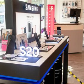 Samsung Galaxy S20 Smartphones auf beleuchtetem Verkaufstisch im Elektronikgeschäft ausgestellt.