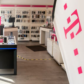 Moderner Telekom-Shop mit Smartphone-Zubehör, Beratungstheke und Telekom-Logo im Vordergrund.